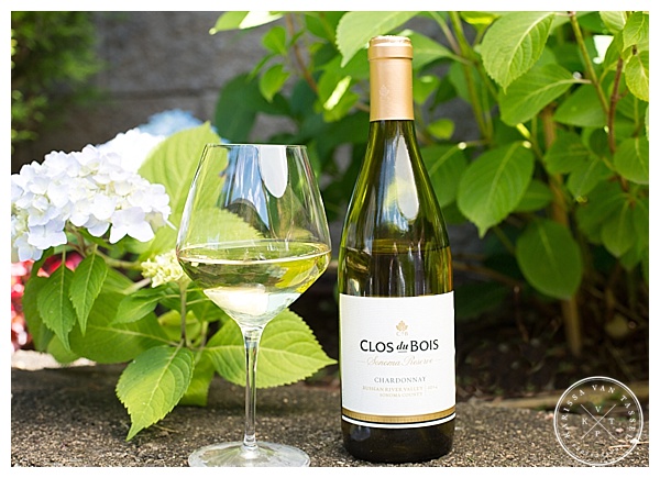A summer photo featuring hydrangeas and a glass of Clos du Bois Chardonnay, with a bottle of the wine next to it